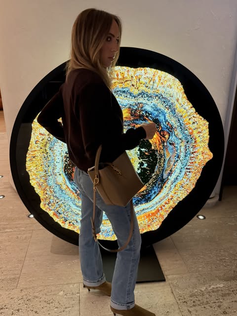 Mara Krainer in front of a circular illuminated artwork